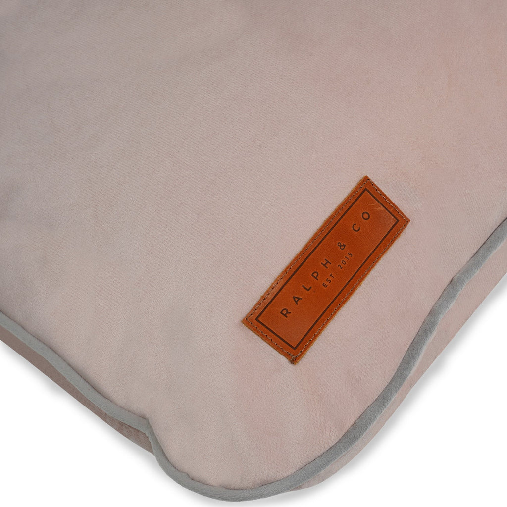 Close-up of the leather Ralph & Co badge and grey piping on the pink crate mattress