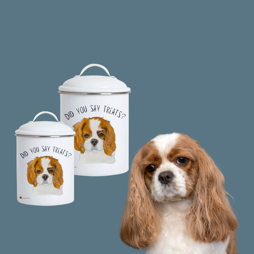 Large and small Cavalier enamel treat jars beside a Blenheim Cavalier King Charles Spaniel