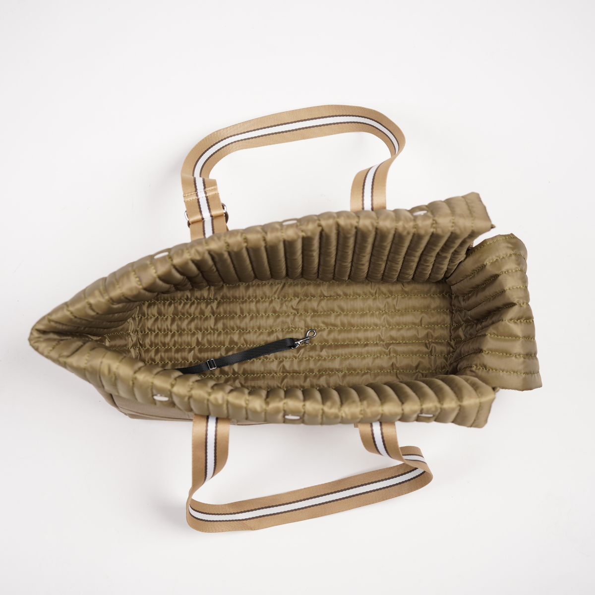 Inside the dog carrier showing quilted lining, padded base and safety clip