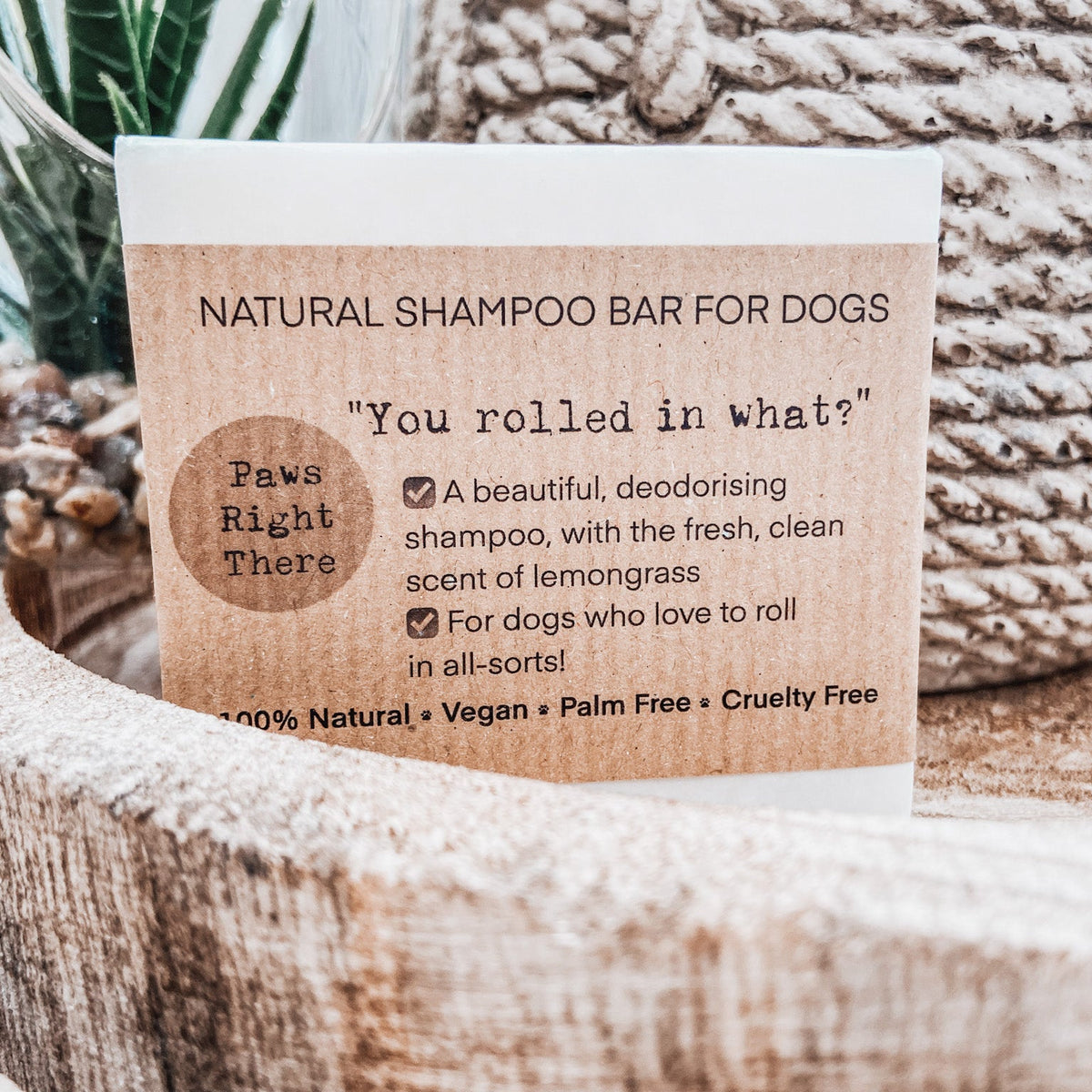 Close-up of You Rolled in What?! shampoo bar label on a wooden stand