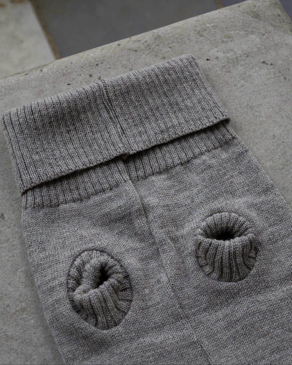 Grey wool dog jumper laid flat showing ribbed leg holes