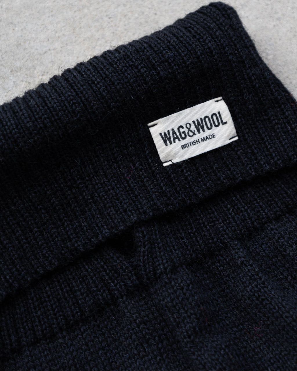 Close-up of the black ribbed roll neck with WAG&WOOL label