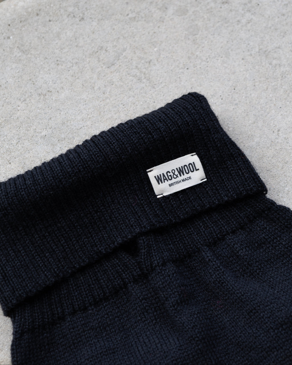 Black wool dog jumper roll neck and label on stone