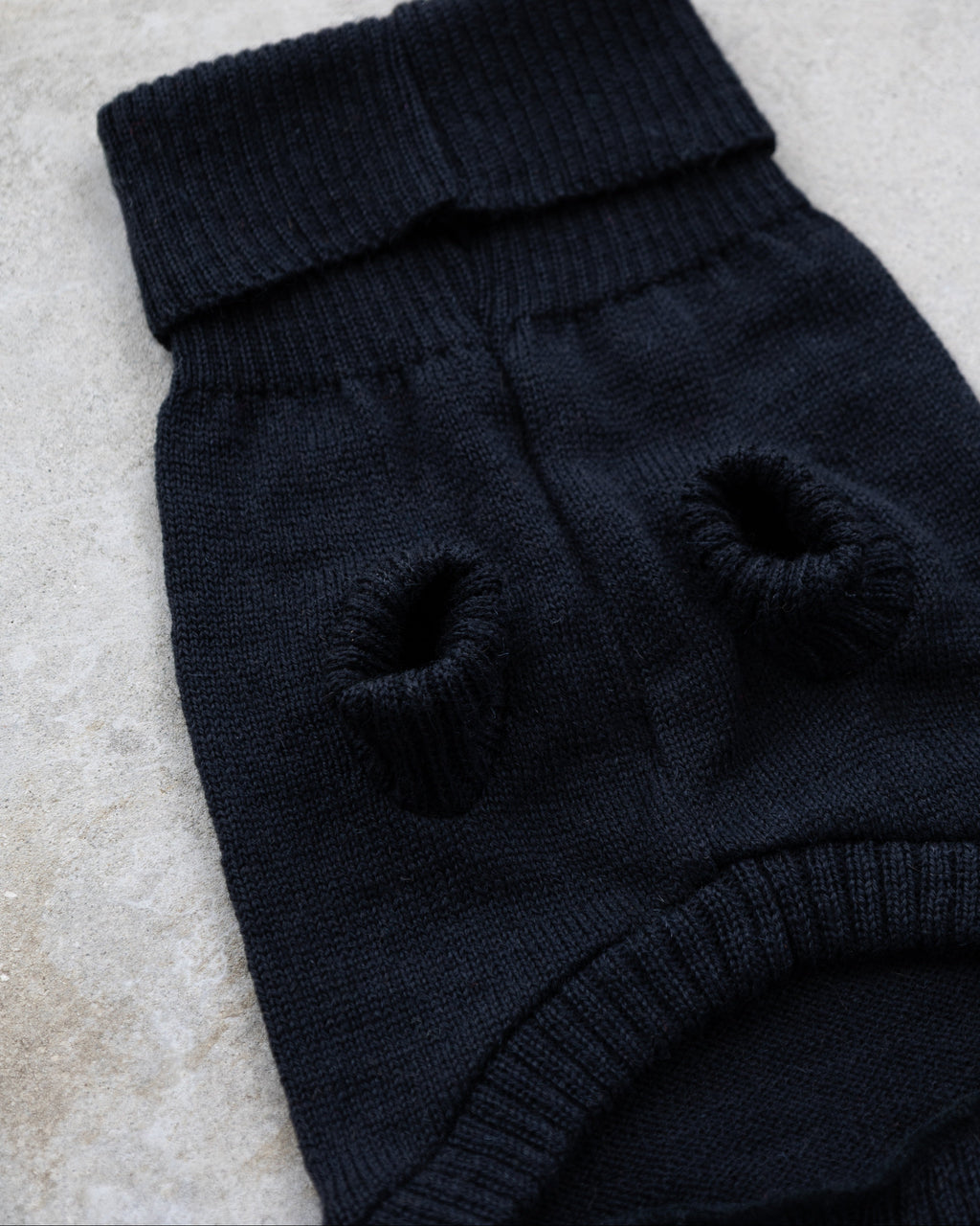 Black wool dog jumper laid flat showing the leg openings
