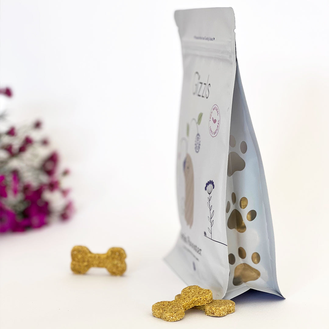 Side view of the Gizzls Brain Booster pouch with paw-shaped window and a bone biscuit
