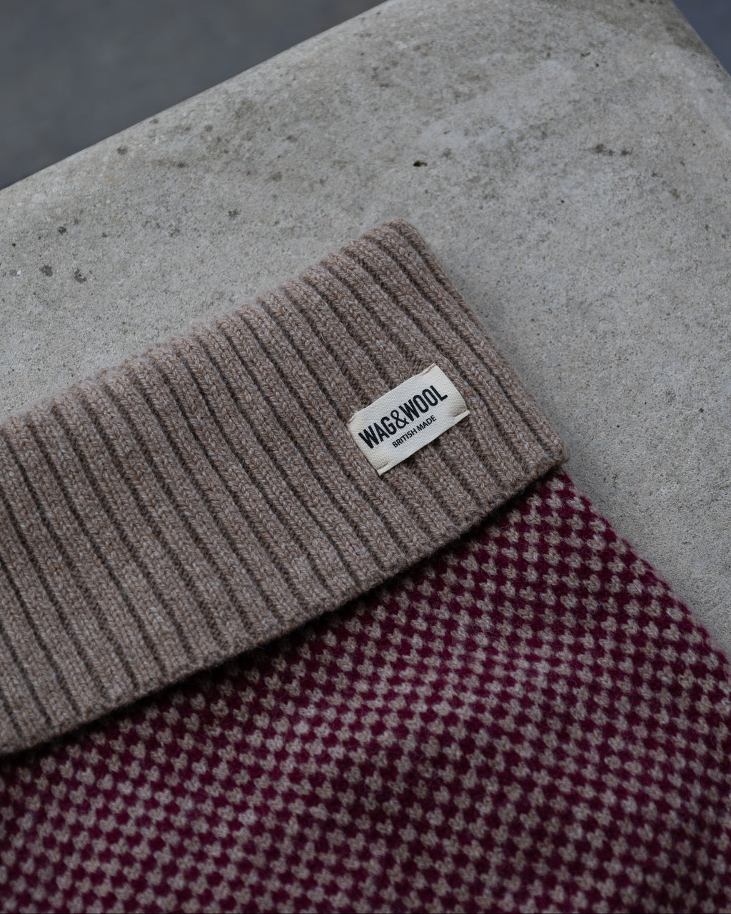 Close-up of the taupe roll neck and label on the burgundy check jumper