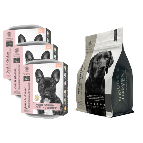 Three Duck & Chicken wet dog food trays stacked beside a Nature's Harvest dry mixer bag