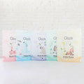 Five pastel Gizzls 100g treat pouches lined up against a white brick wall
