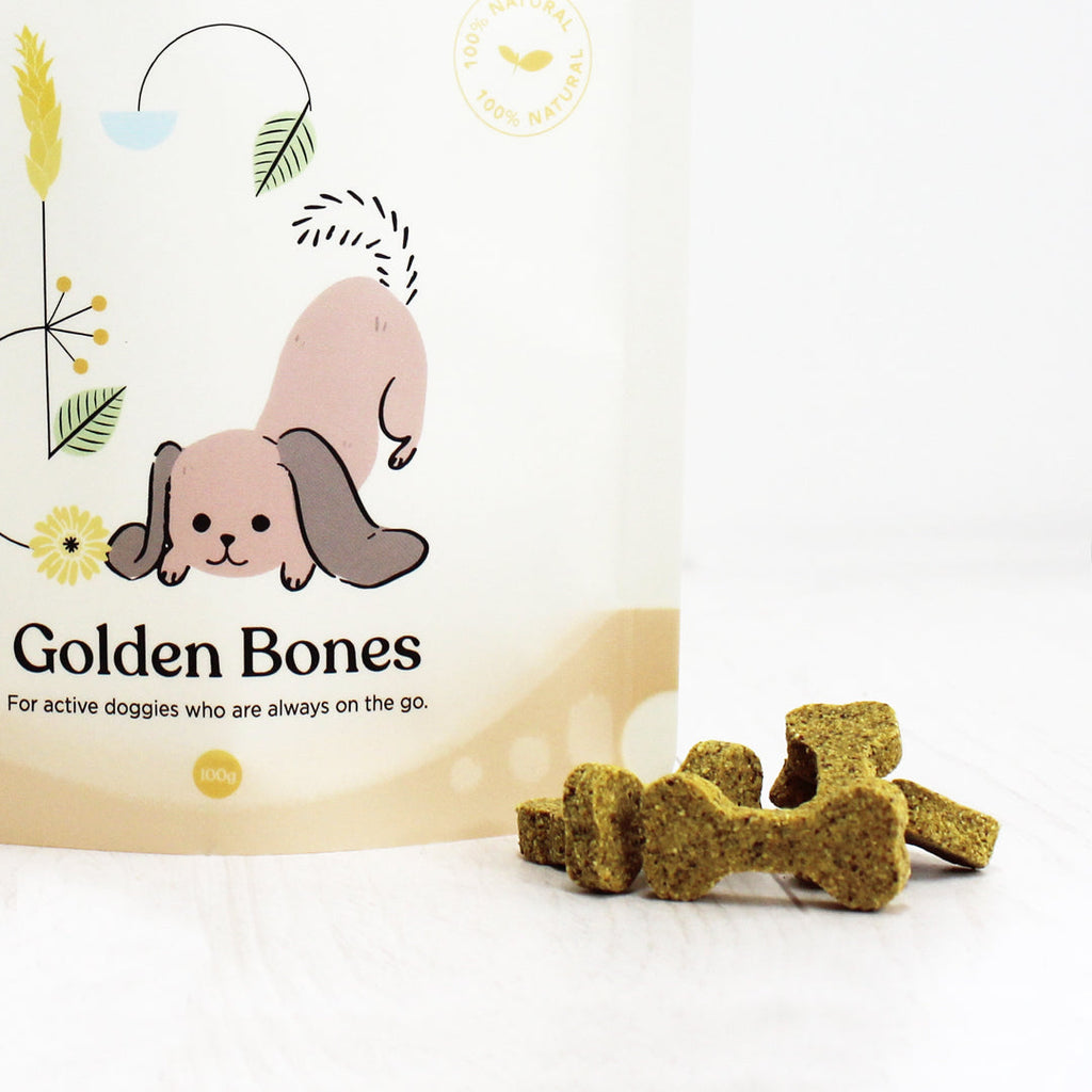 Close-up of Gizzls Golden Bones pouch and golden turmeric bone-shaped biscuits