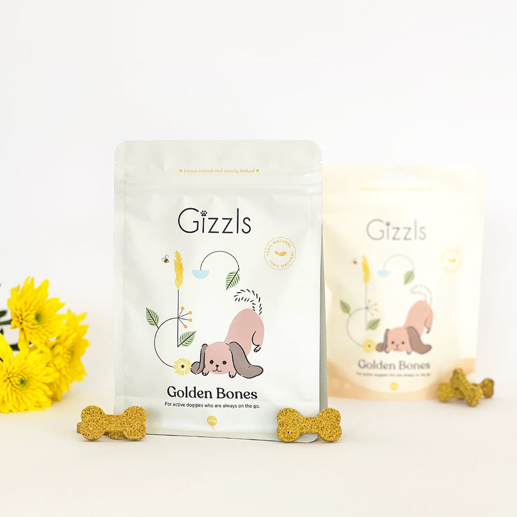 Gizzls Golden Bones 200g and 100g pouches with golden bone biscuits and yellow flowers