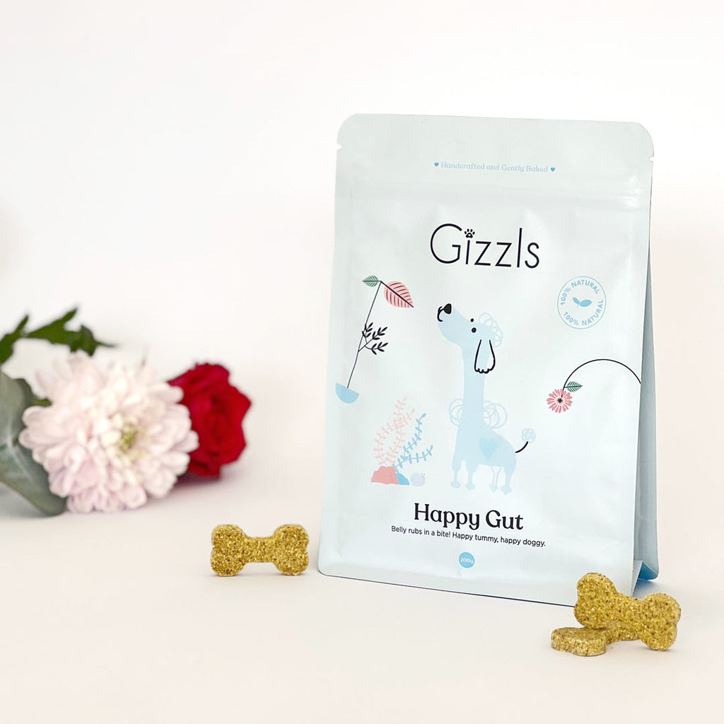 Gizzls Happy Gut 200g pouch with bone biscuits, a pink chrysanthemum and red rose