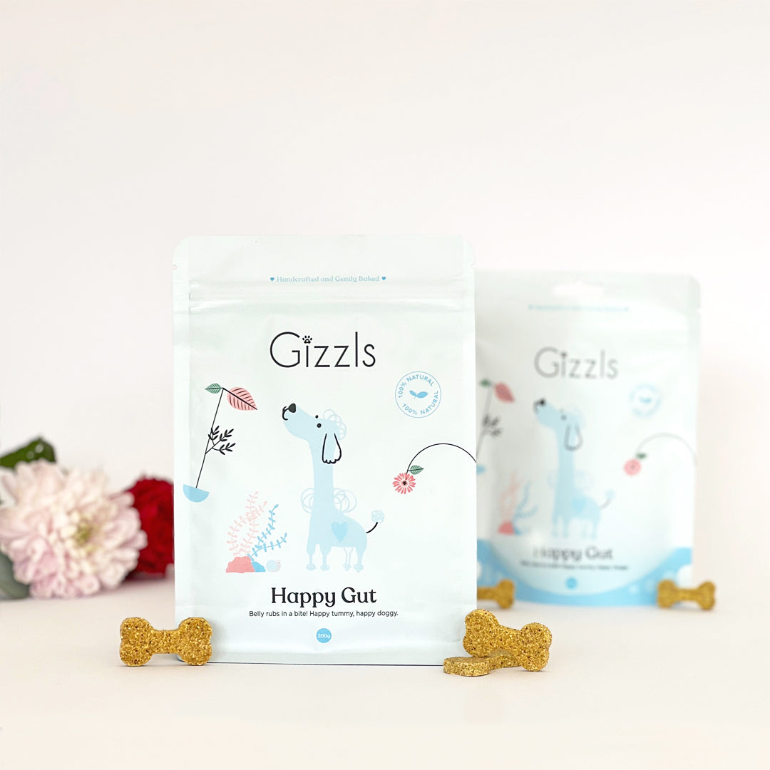 Gizzls Happy Gut 200g and 100g pouches with peanut butter bone biscuits and flowers