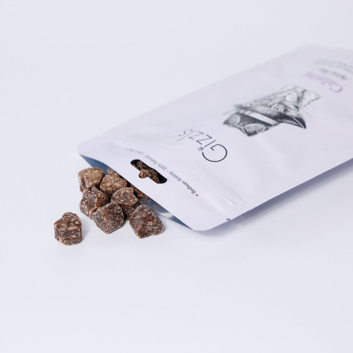 Open Gizzls Calming cat treats pouch with small dark soft liver bites spilling out
