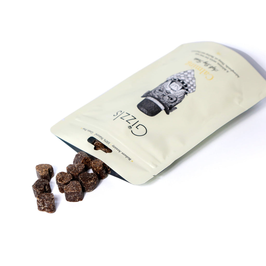 Open Gizzls Calming dog treats pouch with dark ostrich liver cubes spilling out