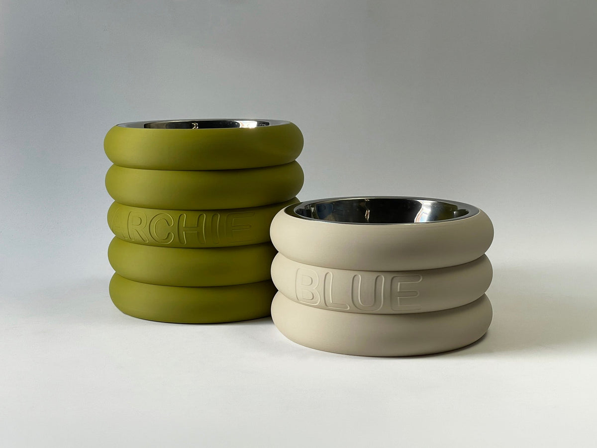 Short rings stands in mustard green and cream with embossed names and steel bowls
