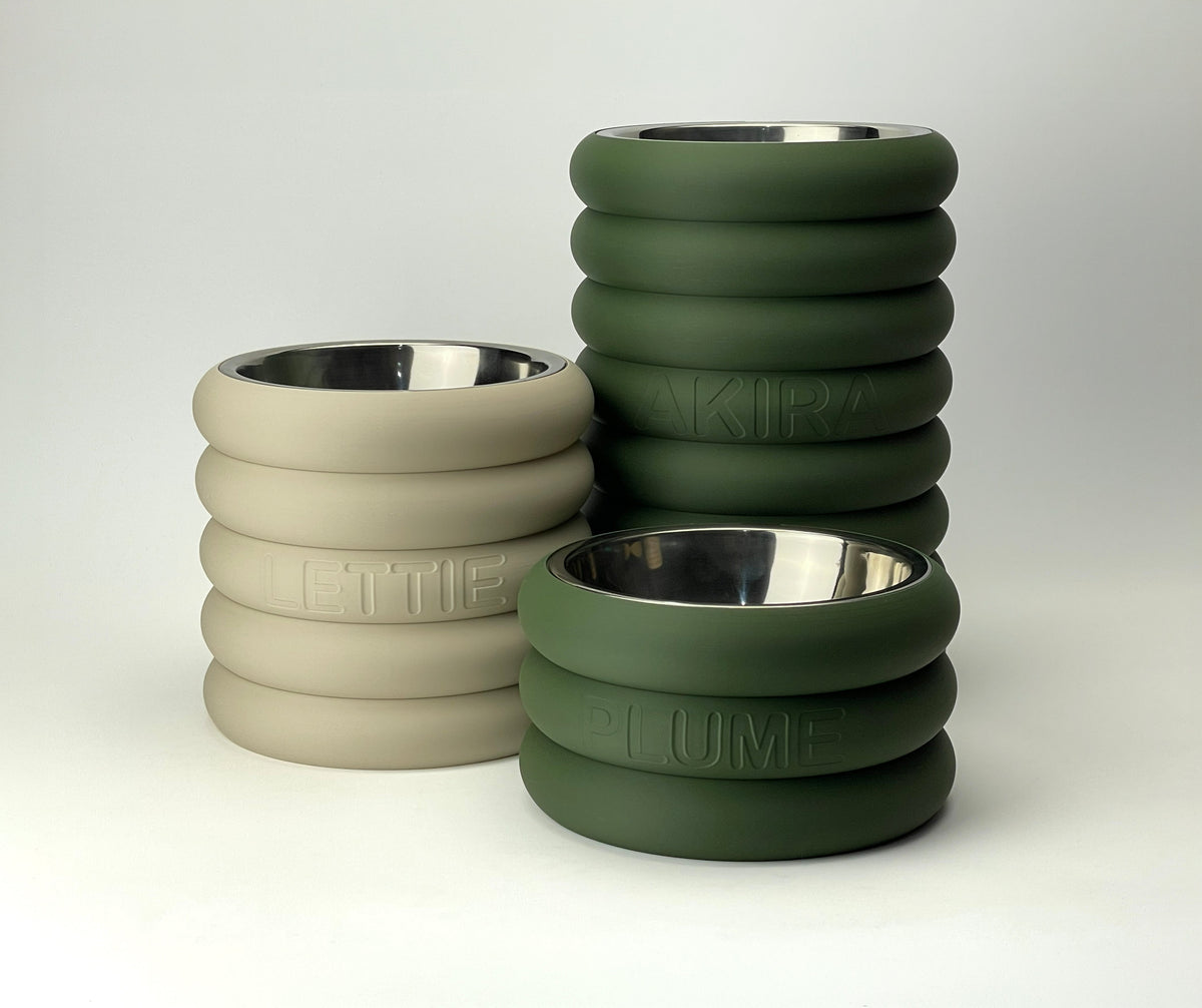 Group of rings raised bowl stands in dark green and beige at different heights