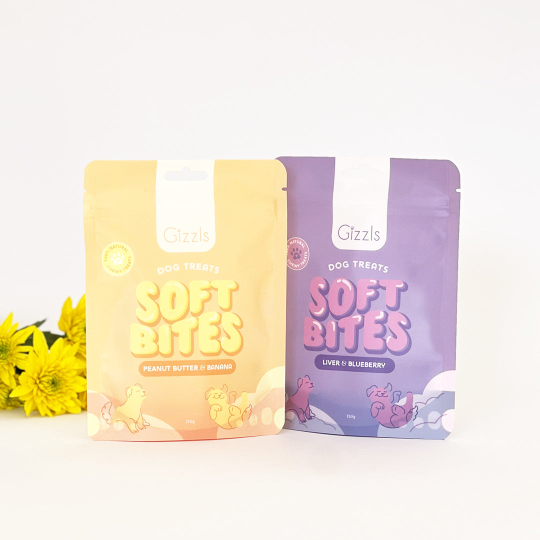 Yellow and purple Soft Bites pouches side by side with yellow flowers