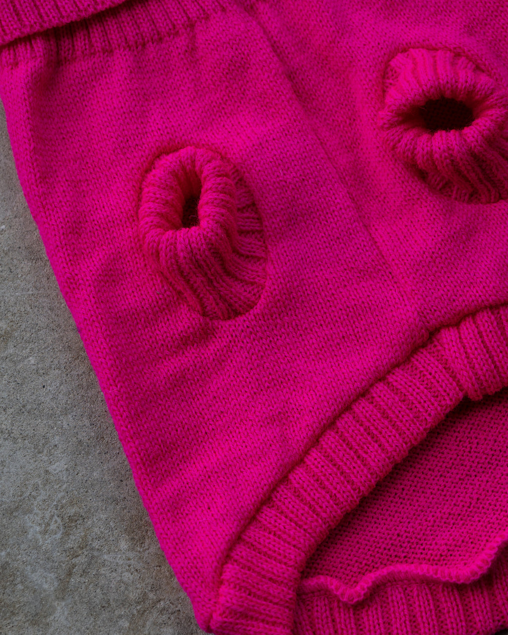 Underside of the pink wool dog jumper showing ribbed leg holes