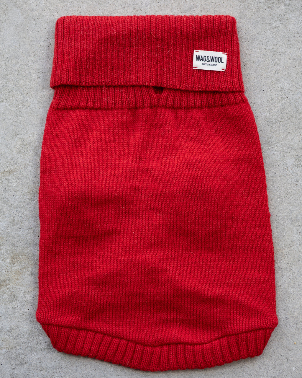 Cherry red wool dog jumper laid flat, top view with label