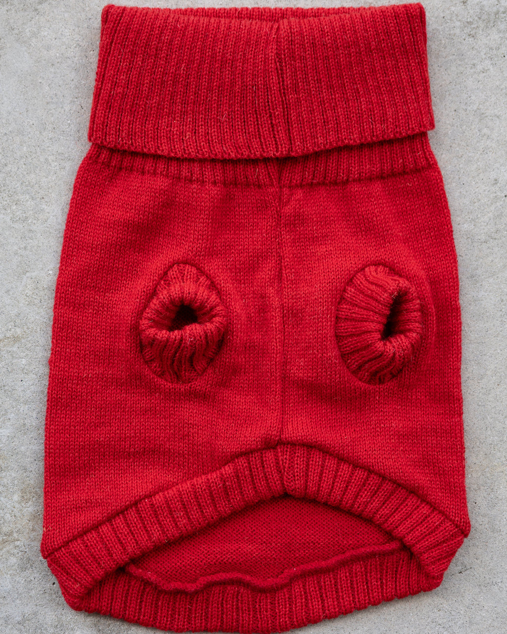 Cherry red wool dog jumper laid flat, underside with leg holes