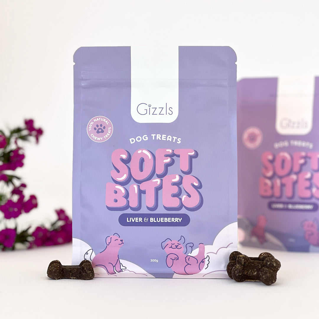 Purple Soft Bites Liver & Blueberry 300g pouch with dark bone treats and magenta flowers