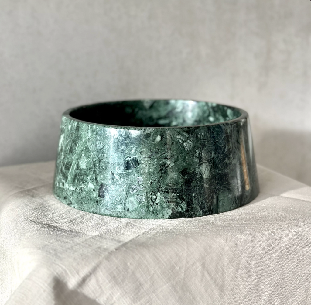 Dark green marble dog bowl on a linen cloth