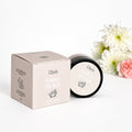Gizzls Nose & Paw Balm in a black tin beside its pale pink box with white and pink flowers