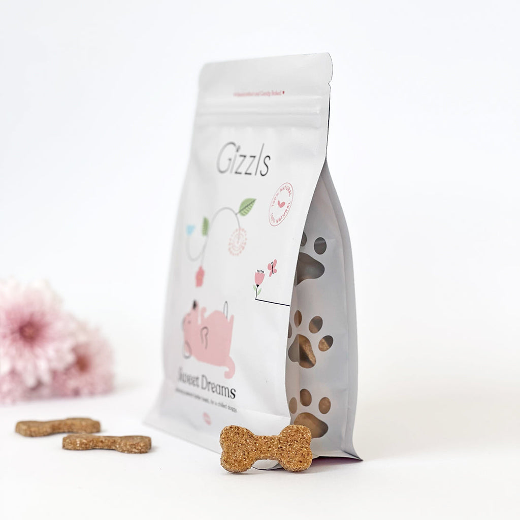 Side view of the Sweet Dreams Big Dog Treats pouch with paw-shaped window and biscuits