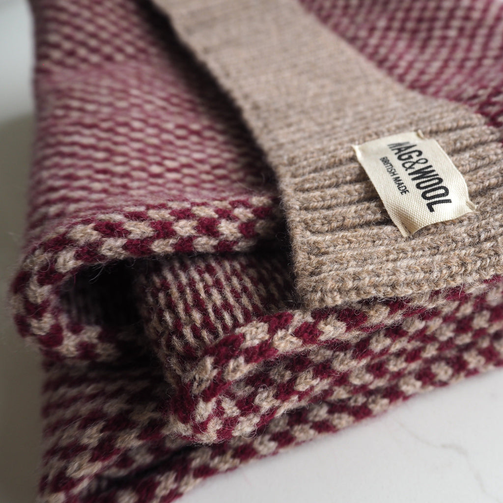 Close-up of the burgundy check lambswool scarf with WAG&WOOL label