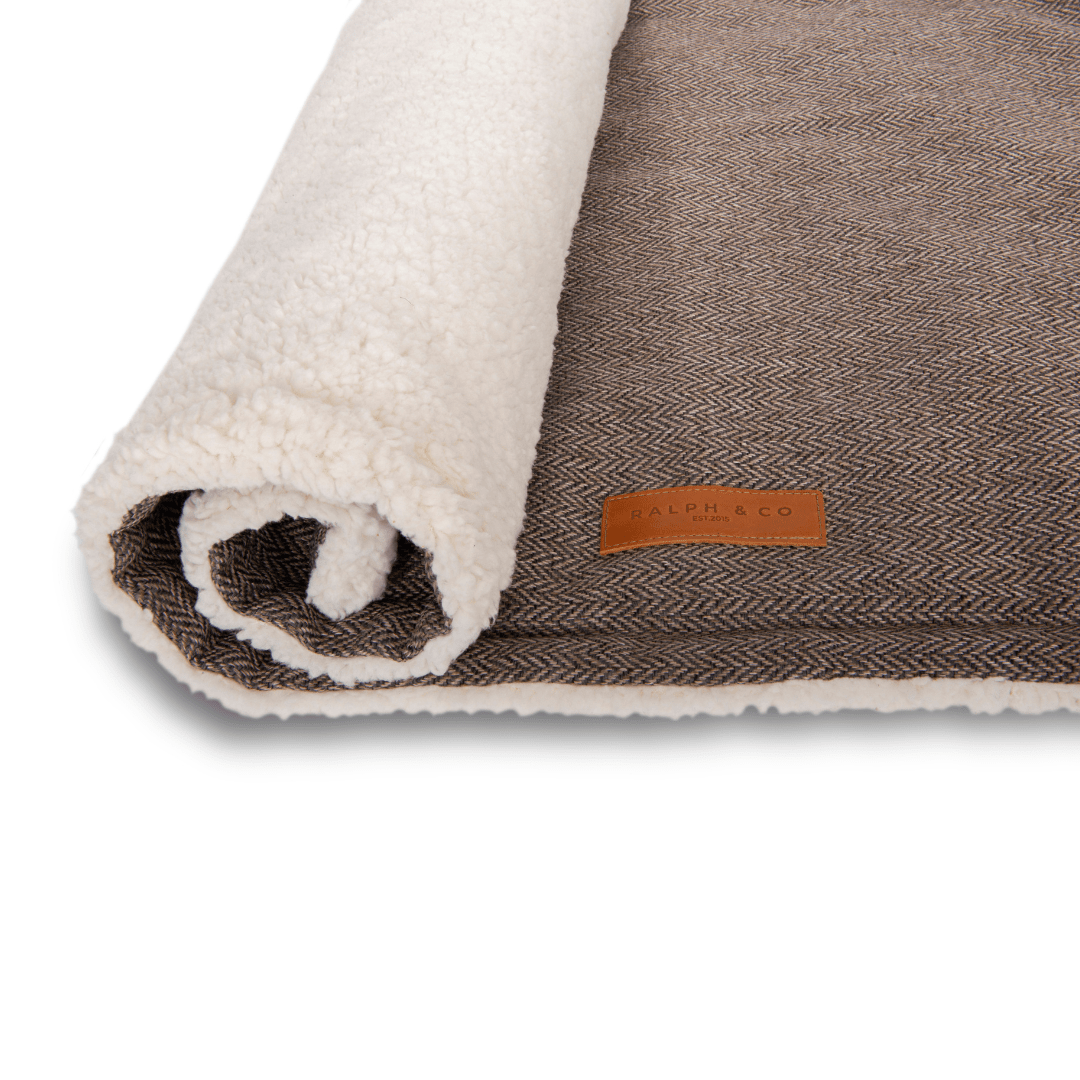 Lincoln brown tweed and faux fur dog blanket rolled up with leather badge