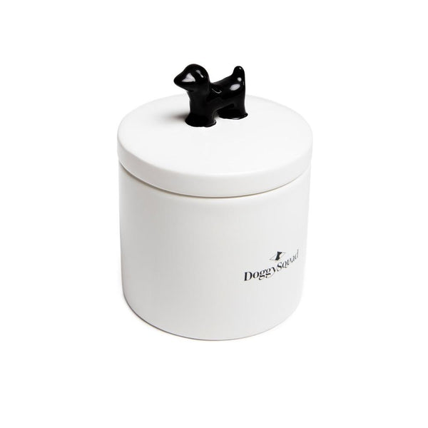 White ceramic dog treat jar seen from above at an angle, with black dog-shaped lid handle