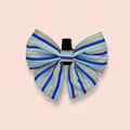 Sea Breeze Stripes Dog Sailor Bow in pale and royal blue stripes on a pink background