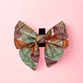 Autumn Breeze Dog Sailor Bow with sage, rust and brown leaf print on a pink background
