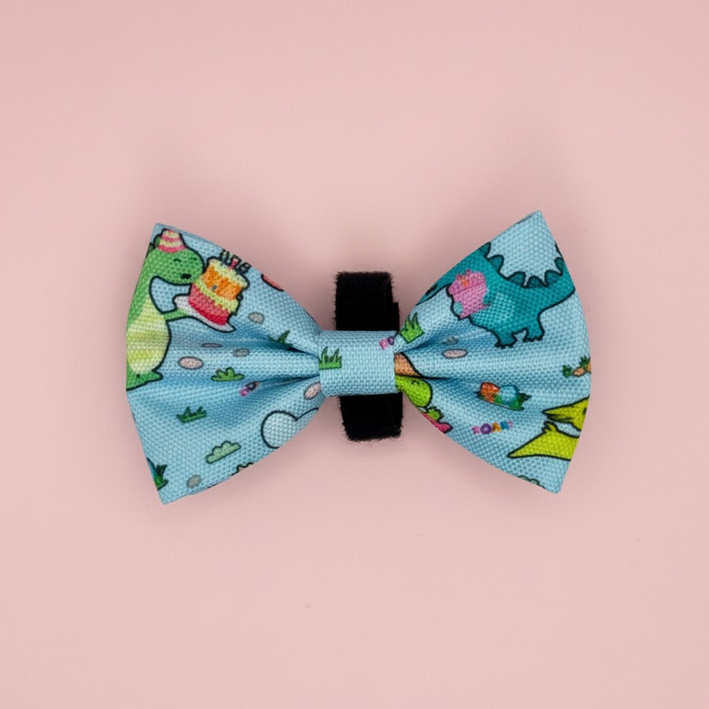 Jurassic Party Dog Bow Tie with colourful dinosaur print on light blue, pink background