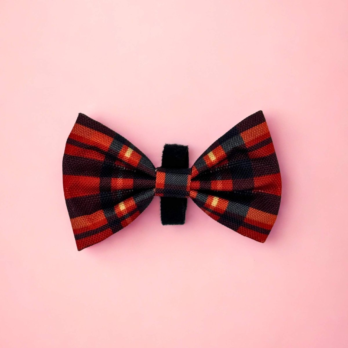 Red Tartan Dog Bow Tie in red, black and orange tartan on a pink background