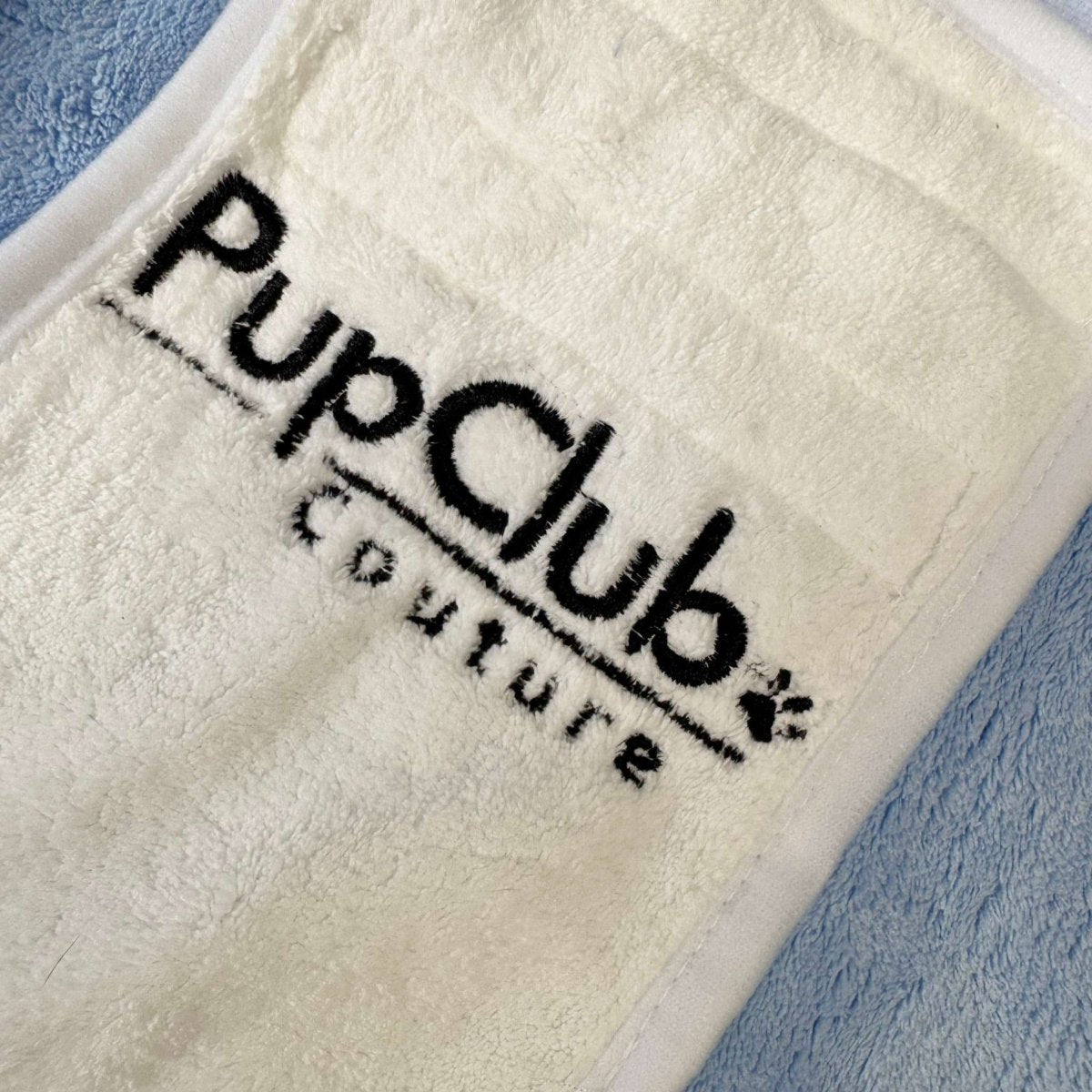 Close-up of the embroidered PupClub Couture logo on the drying robe belly patch