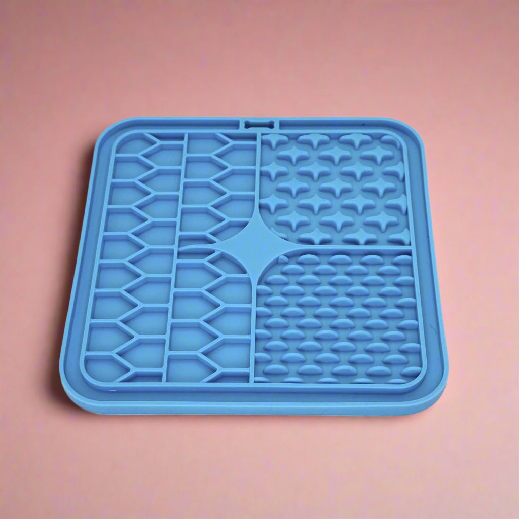 Blue Silicone Dog Lick Mat on a pink background showing textured patterns