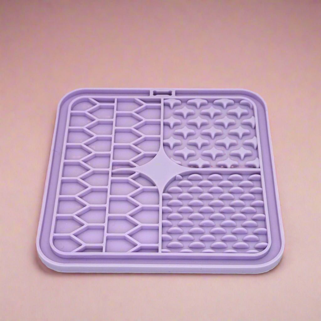 Lilac Silicone Dog Lick Mat on a pink background showing textured patterns