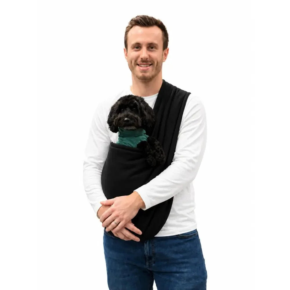Man wearing a black Plain Fleece Dog Sling with a small black cockapoo inside