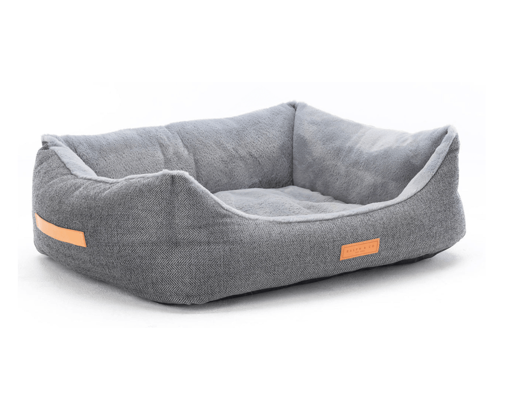 Balmoral herringbone bolster bed at an angle showing the leather side handle