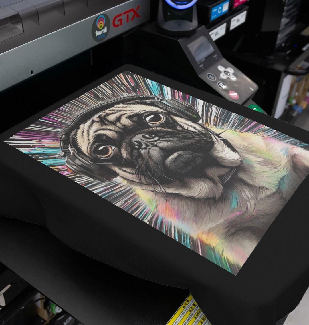 Black T-shirt being printed with the colourful pug-in-headphones artwork on a garment printer