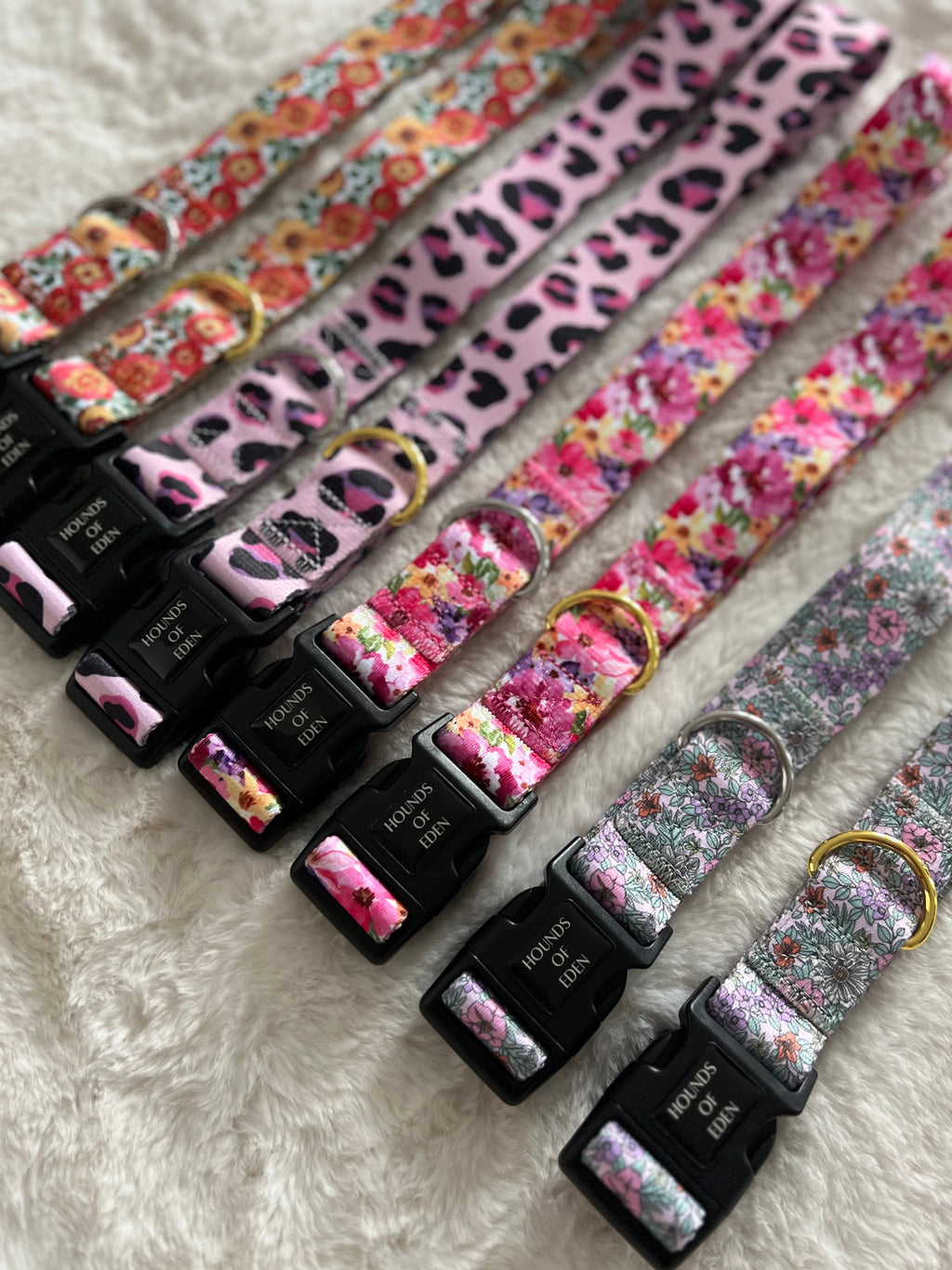 Hounds of Eden pink, leopard and floral print collars laid out on a rug
