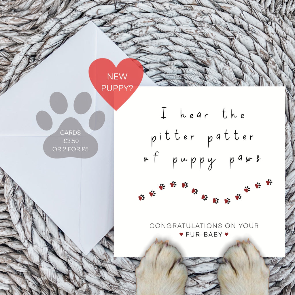 New puppy congratulations card with envelope and dog paws on a woven mat