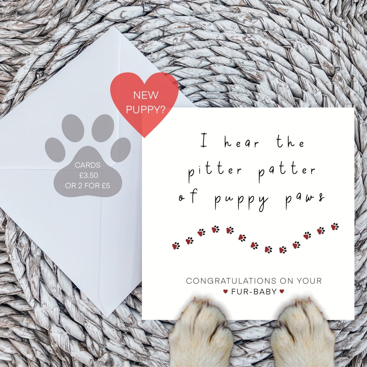 New puppy congratulations card with envelope and dog paws on a woven mat