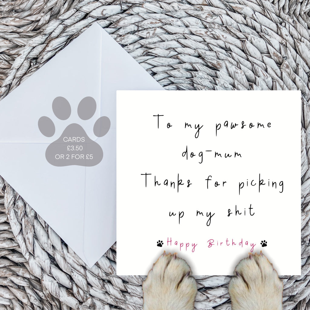 Dog mum birthday card and white envelope on a woven mat with dog paws in front