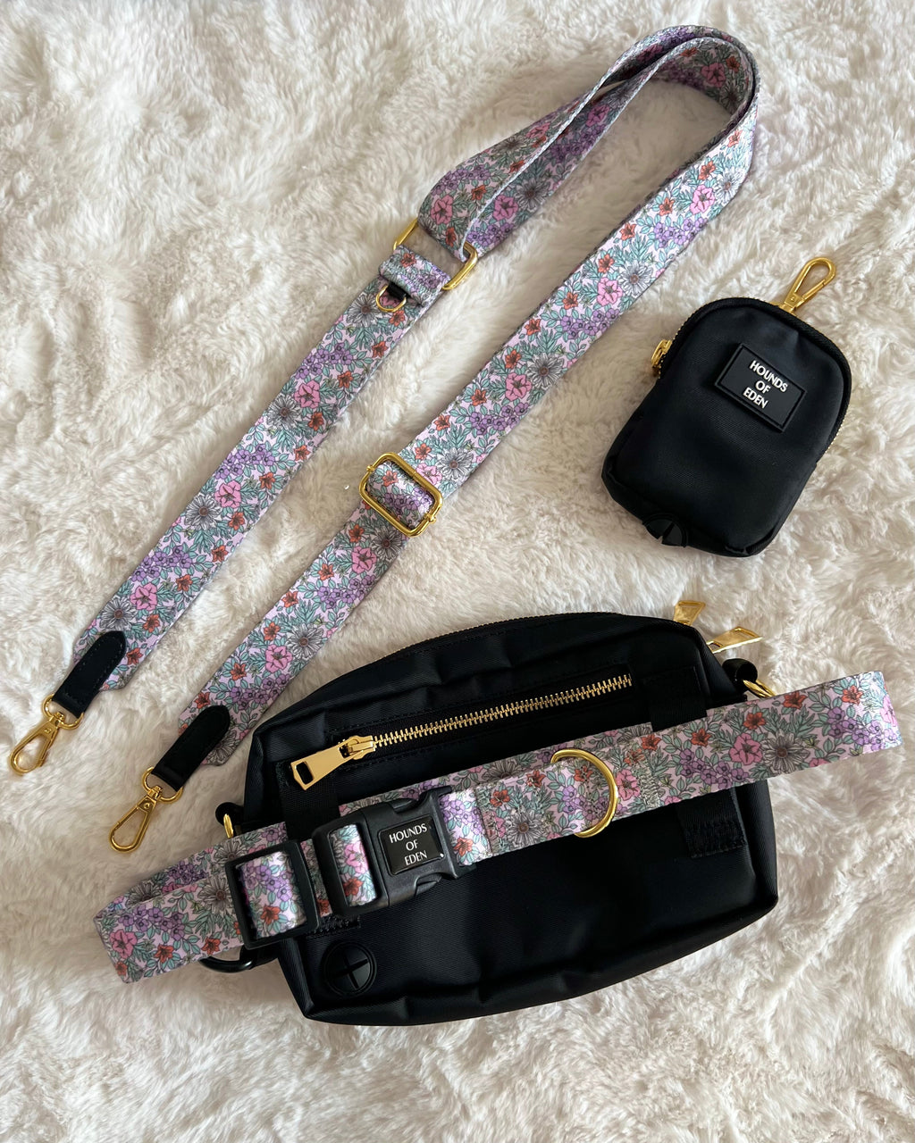 Black treat pouch and walking bag with a floral shoulder strap on a rug