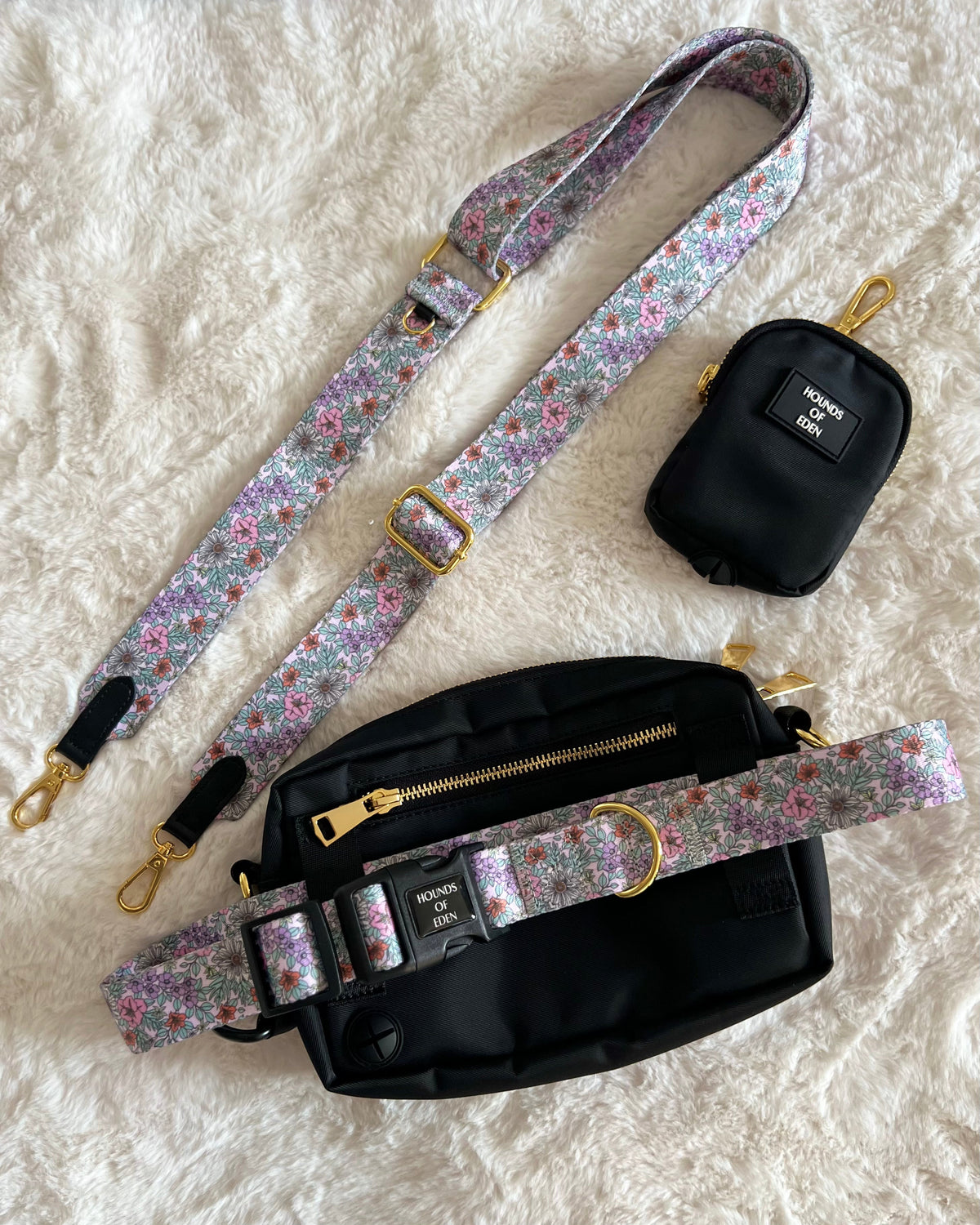 Black treat pouch and walking bag with a floral shoulder strap on a rug