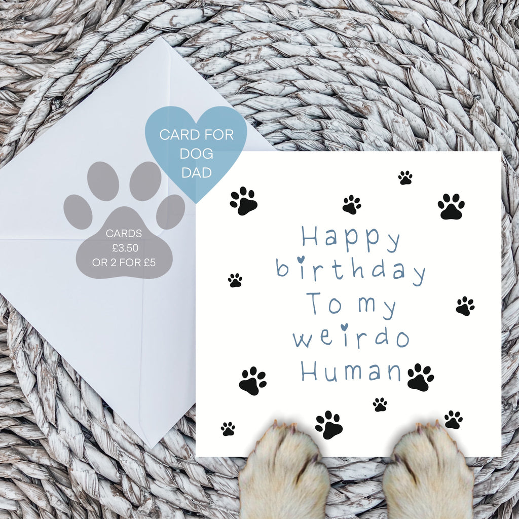 Blue weirdo human birthday card with envelope and dog paws on a woven mat