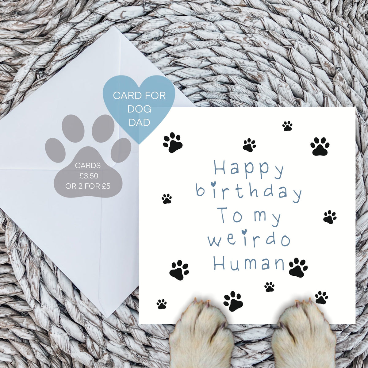 Blue weirdo human birthday card with envelope and dog paws on a woven mat