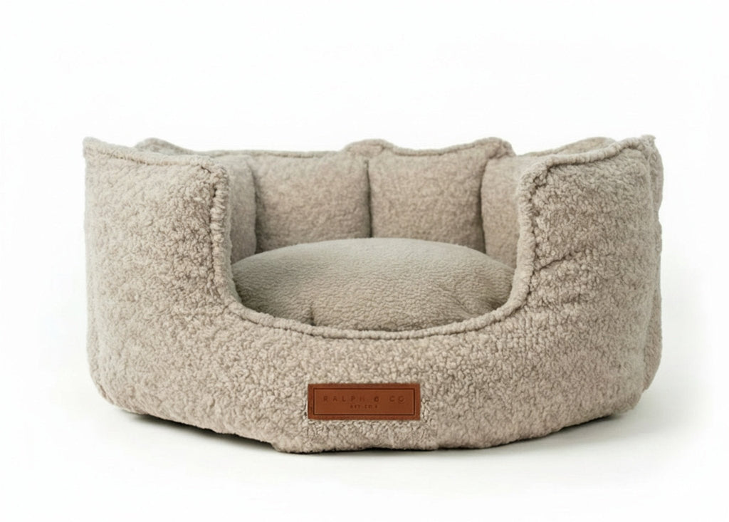 Cotswold round high wall dog bed in oatmeal bouclé with leather badge